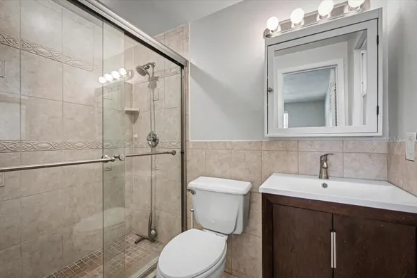a bathroom with a granite countertop sink a toilet and shower