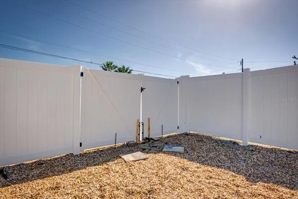 a front view of a house with a dirt yard and a large window