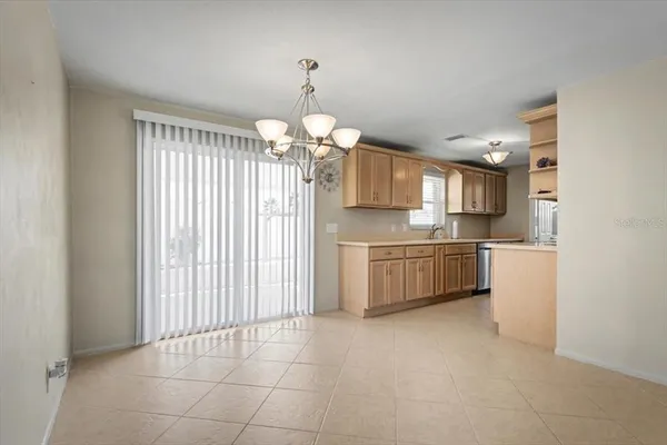 a view of empty room with kitchen and window