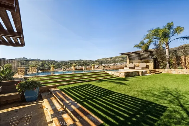 a view of a swimming pool with lawn chairs and plants