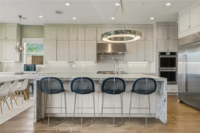 a kitchen with stainless steel appliances granite countertop a stove a sink and a refrigerator