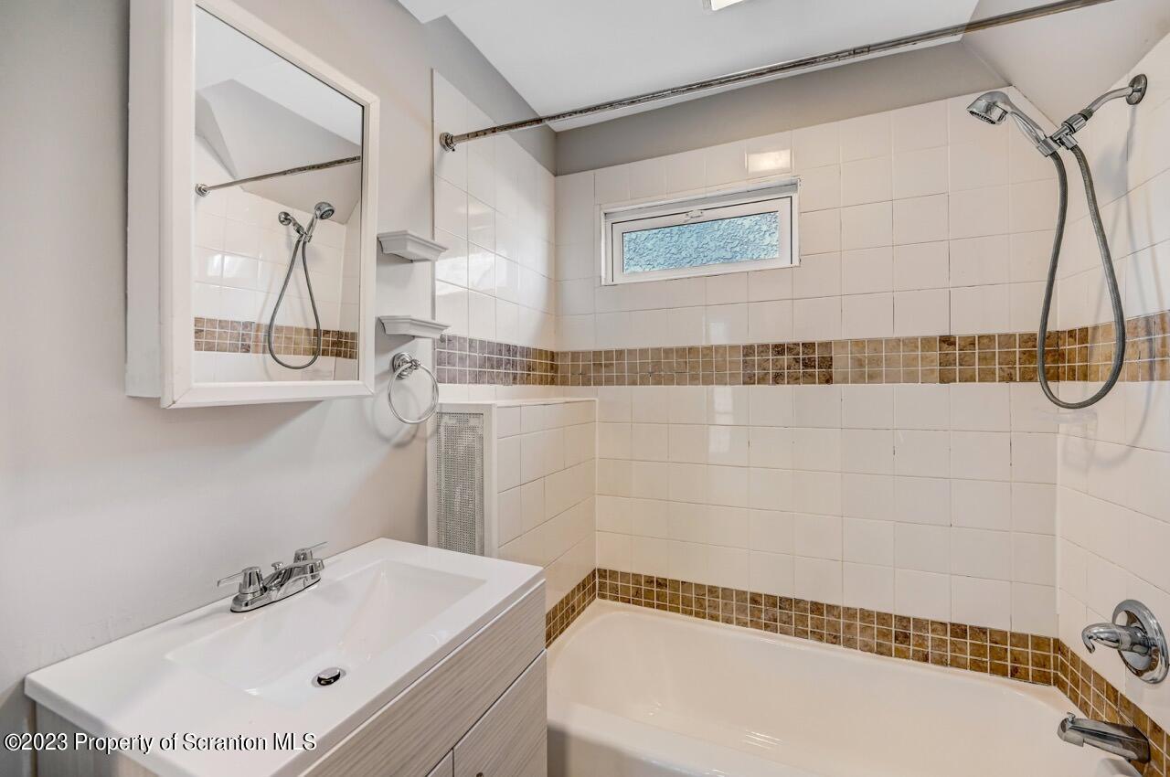 915 Ridge Avenue Scranton, PA 18510 - Photo 23 of 39 a bathroom with a white bath tub sitting next to a white sink and vanity