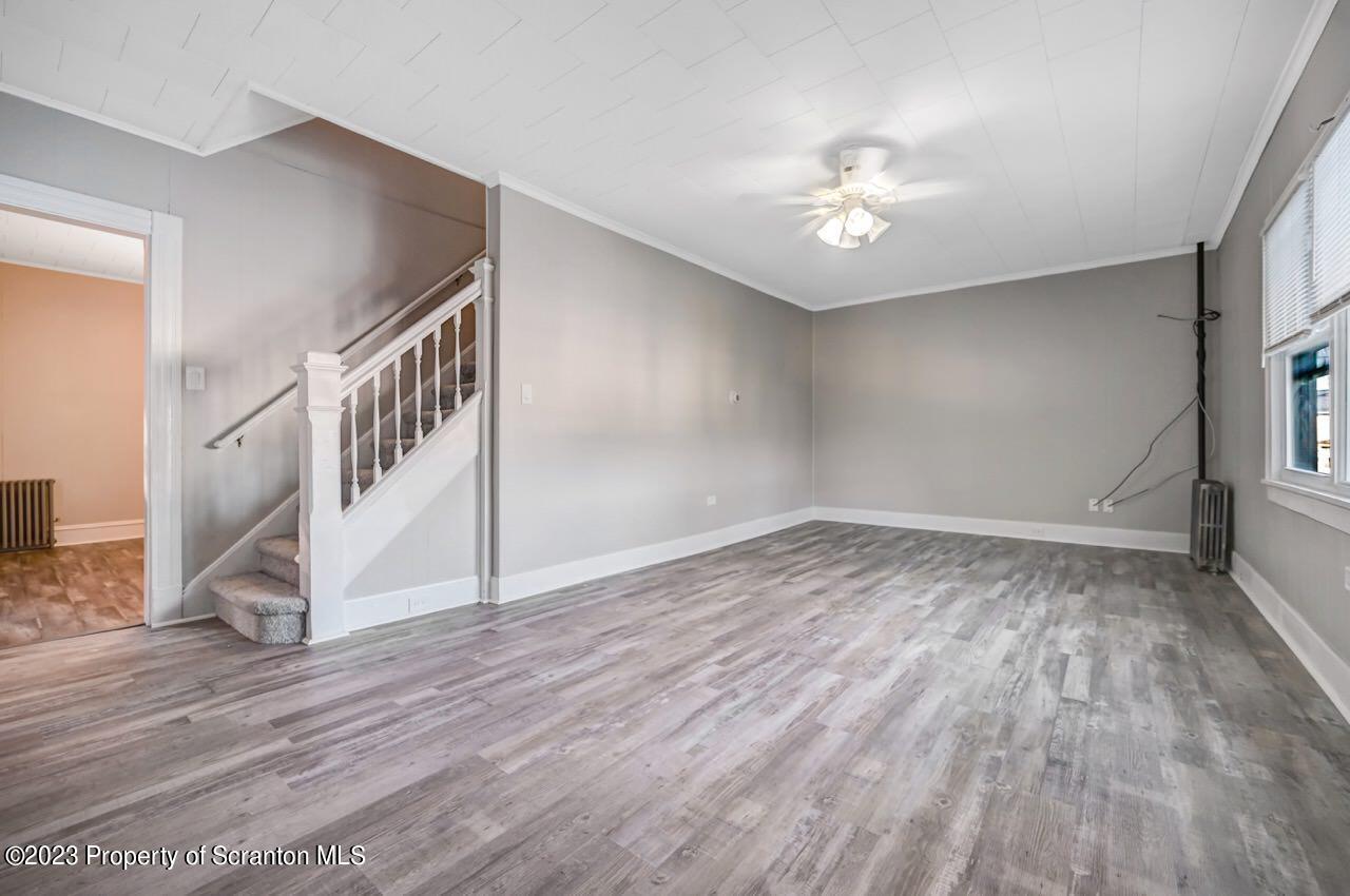 915 Ridge Avenue Scranton, PA 18510 - Photo 4 of 39 a view of an empty room with wooden floor and a ceiling fan