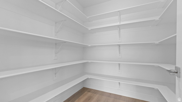 4170 North 560th West, Unit 6 Tooele, UT 84074 - Photo 6 of 20 Expansive corner pantry featuring white shelving, multiple storage tiers, and wood-finish flooring