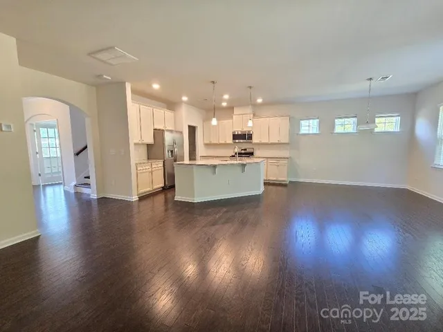 a living room with hard wood floors and a kitchen
