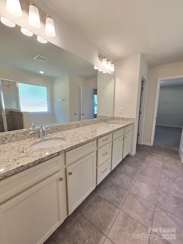 a bathroom with a granite countertop sink a mirror and a vanity