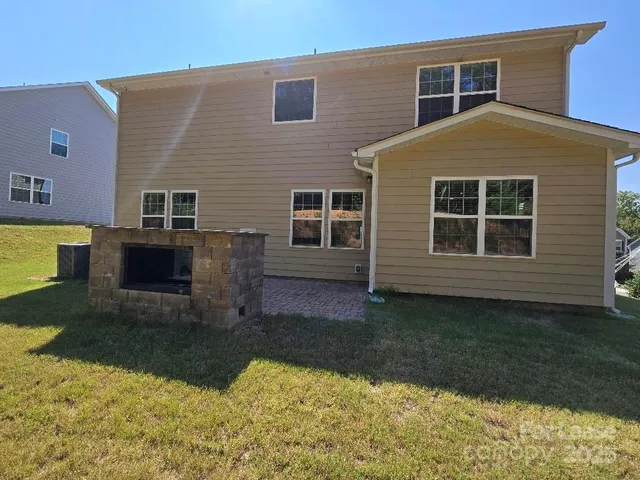 a backyard of a house with a yard and large trees