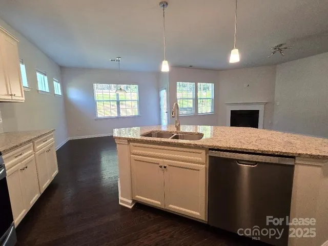 a kitchen with stainless steel appliances granite countertop a sink a stove a refrigerator and a oven with wooden floor