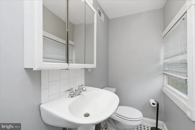 a bathroom with a sink a toilet and mirror