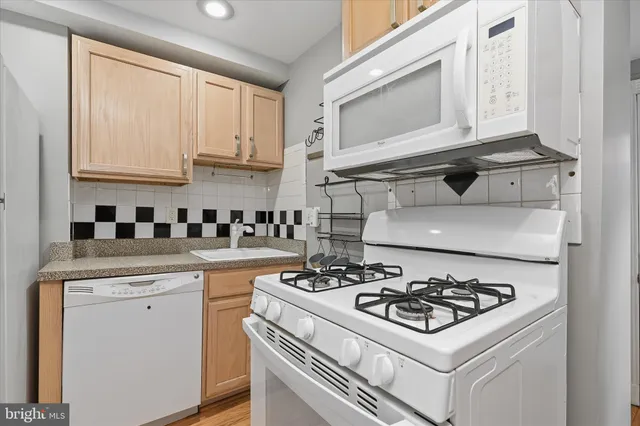 a white stove top oven sitting inside of a kitchen