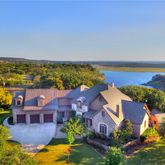 an aerial view of residential houses with outdoor space and a lake view