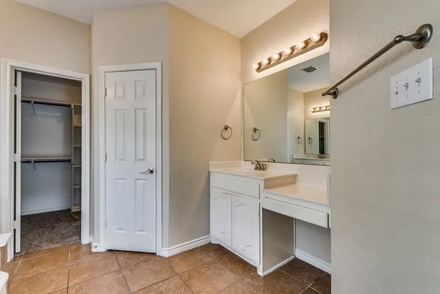 a spacious bathroom with a double vanity sink and mirror