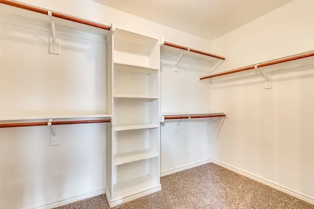 a view of walk in closet with empty racks