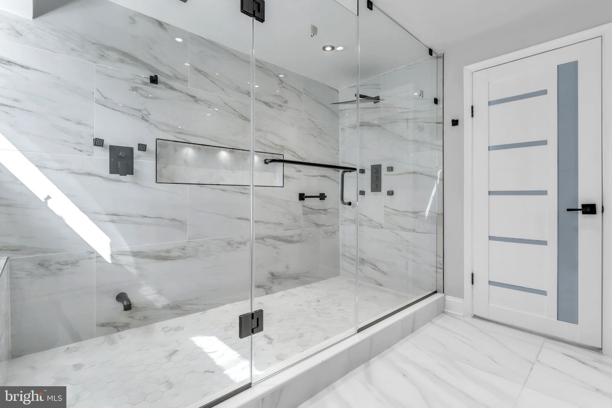 14933 Wellwood Road Silver Spring, MD 20905 - Photo 36 of 50 Sleek marble-tile shower in primary bathroom.