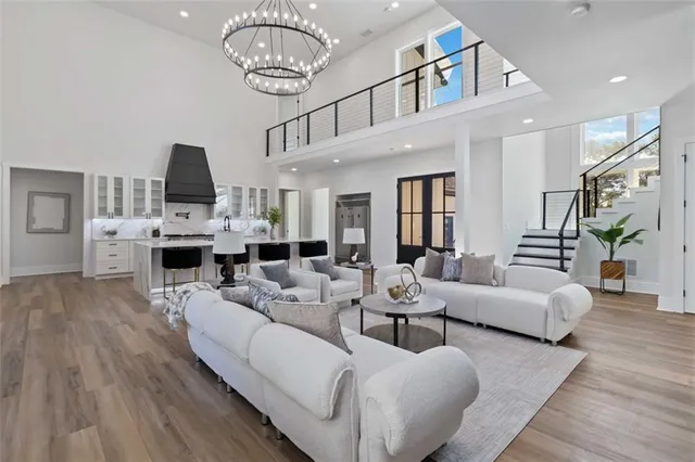 a living room with furniture kitchen view and a wooden floor