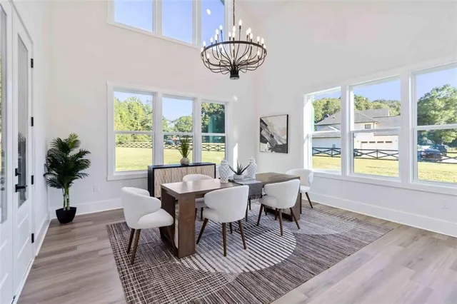a dining room with wooden floor a chandelier a glass table and chairs