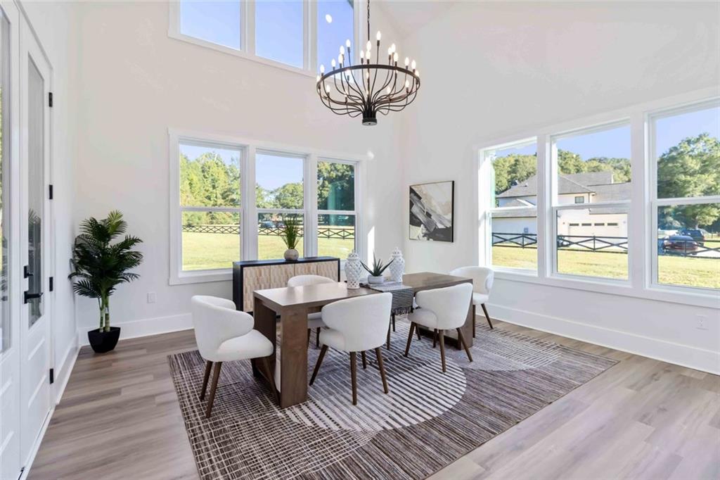 1604 Greendale Road Covington, GA 30014 - Photo 6 of 68 a dining room with wooden floor a chandelier a glass table and chairs