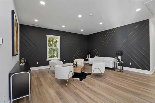 a living room with couches and painted walls with wooden floor
