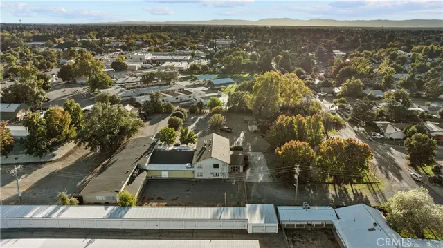 a view of a house with a big yard and large trees