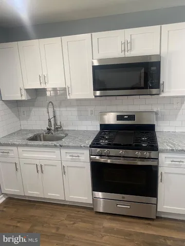 a kitchen with stainless steel appliances granite countertop a stove microwave and sink