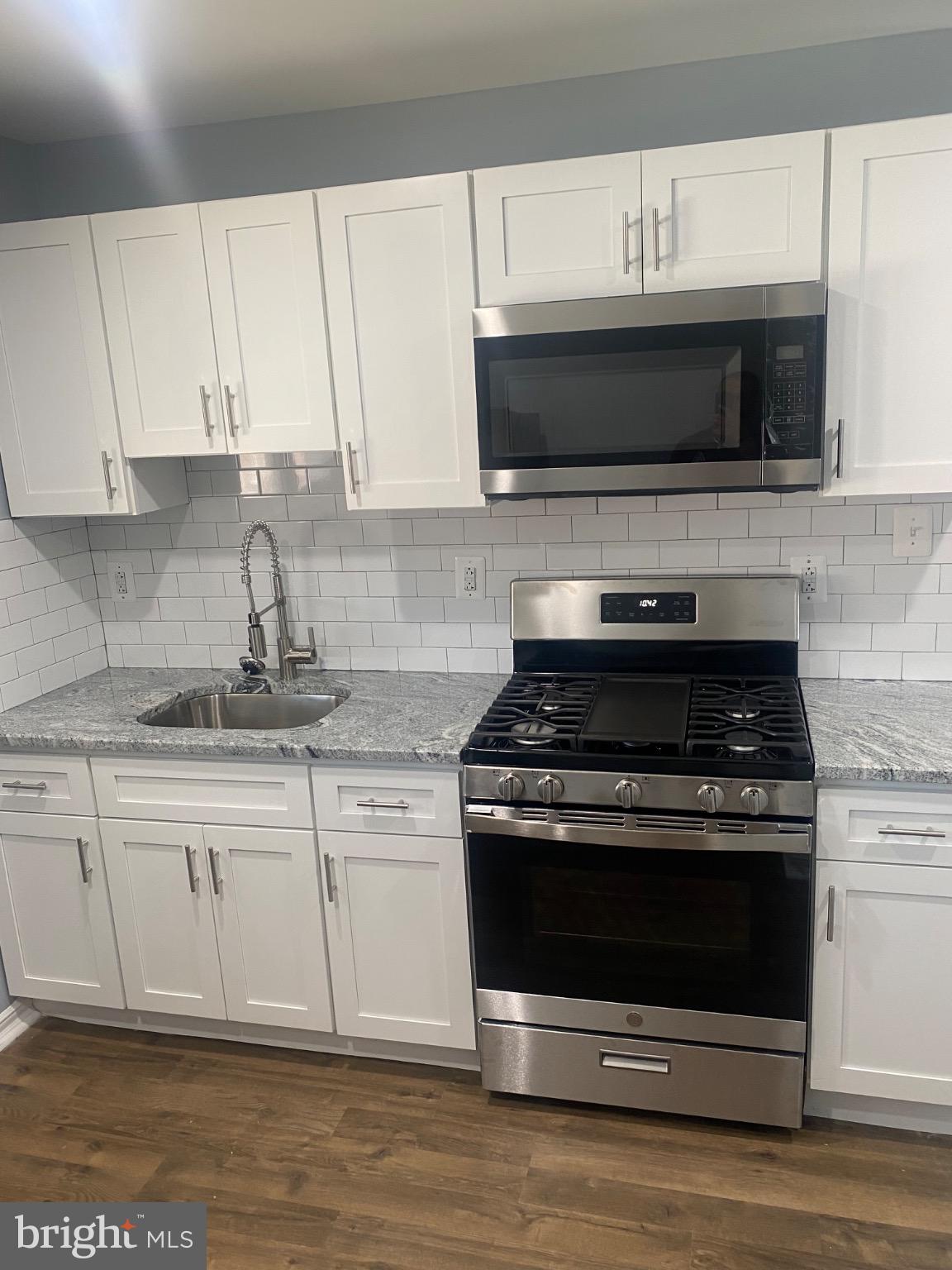 6254 Everett Street, Unit 3 Philadelphia, PA 19149 - Photo 1 of 8 a kitchen with stainless steel appliances granite countertop a stove microwave and sink
