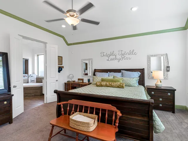 a bedroom with a bed a chandelier and a dresser