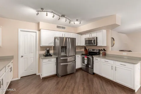 a kitchen with white cabinets and stainless steel appliances
