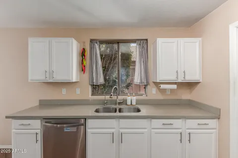 a kitchen with stainless steel appliances granite countertop a sink and a white cabinets