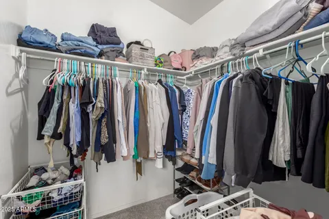 a view of walk in closet with clothes and shoes
