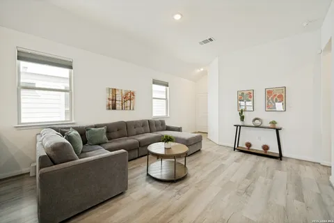 a living room with furniture and wooden floor