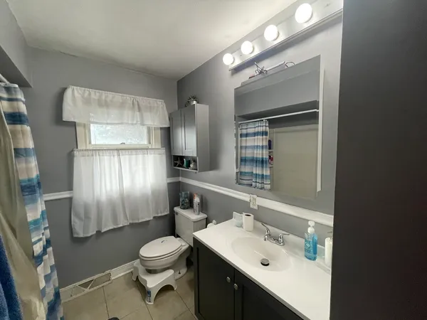 a bathroom with a toilet a sink and mirror