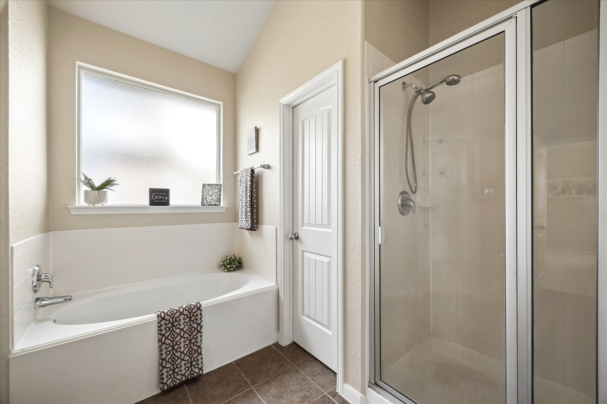 7806 Summer Night Lane Rosenberg, TX 77469 - Photo 16 of 23 The primary bathroom features a separate glass-enclosed shower and a built-in soaking tub with marble-style tile surrounds.
