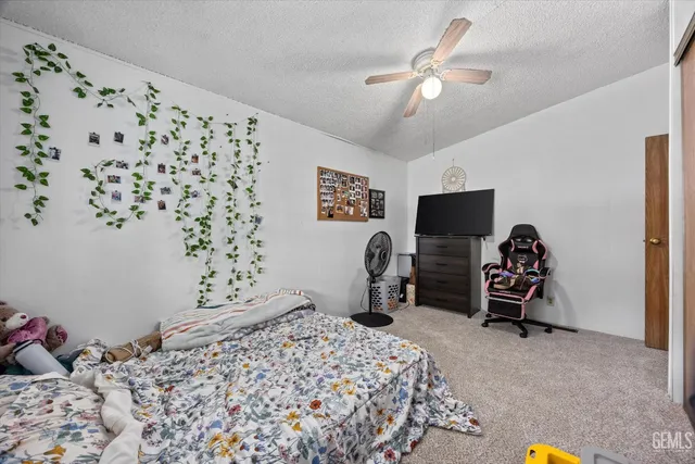 a bedroom with a bed and flat tv screen on the dresser