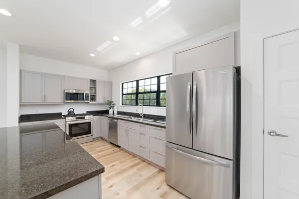 a kitchen with stainless steel appliances granite countertop a refrigerator sink and stove
