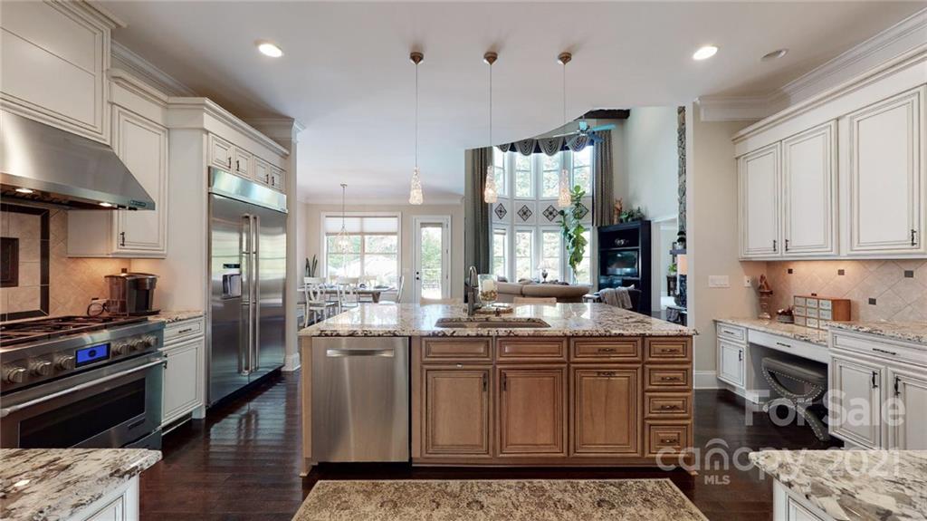 2130 Pondmeade Lane Matthews, NC 28104 - Photo 26 of 47 a kitchen with stainless steel appliances granite countertop a stove top oven a sink dishwasher and cabinets with wooden floor