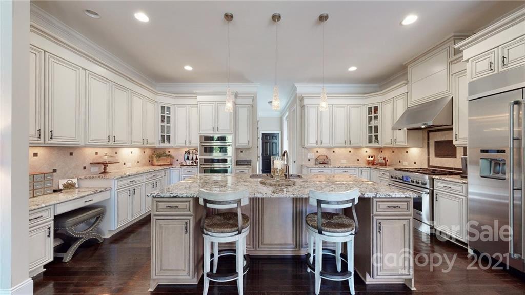2130 Pondmeade Lane Matthews, NC 28104 - Photo 29 of 47 a kitchen with stainless steel appliances granite countertop a stove top oven a refrigerator a sink and chairs