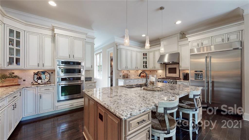 2130 Pondmeade Lane Matthews, NC 28104 - Photo 30 of 47 a kitchen with stainless steel appliances granite countertop a stove refrigerator and cabinets