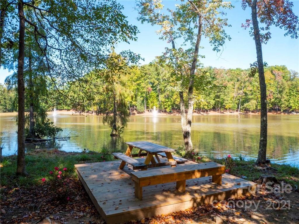 2130 Pondmeade Lane Matthews, NC 28104 - Photo 47 of 47 a view of a lake with lawn chairs under an umbrella