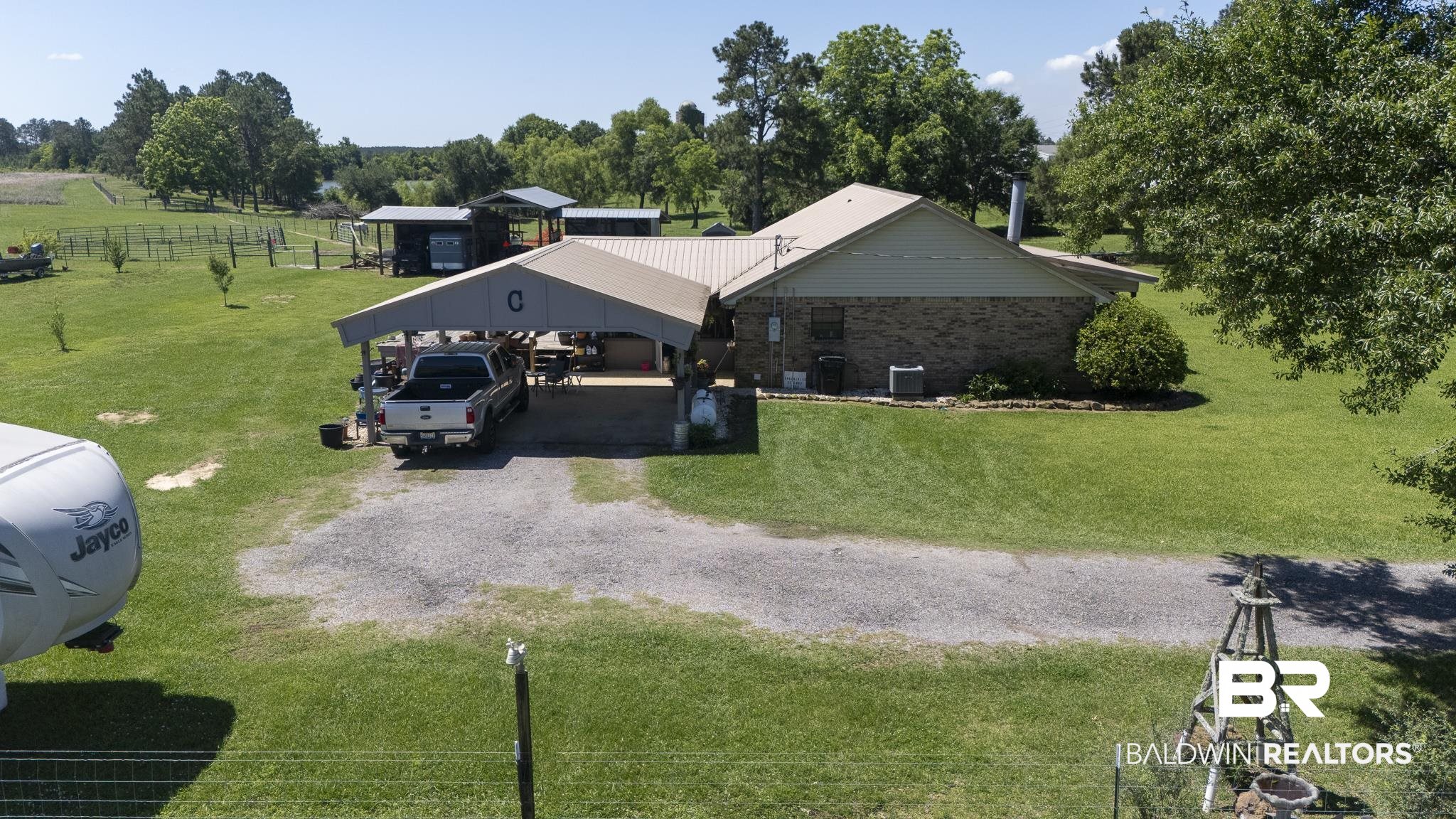 30580 County Road 49 Loxley, AL 36551 - Photo 25 of 32 Expansive green lawn surrounding a brick residence with a metal roof