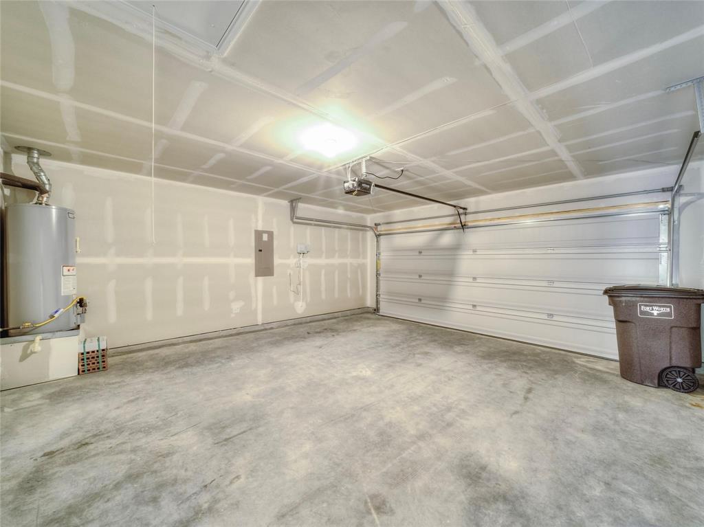 357 Sun Bluff Road Fort Worth, TX 76052 - Photo 35 of 35 Spacious garage with a concrete floor, overhead lighting, and a white panel garage door