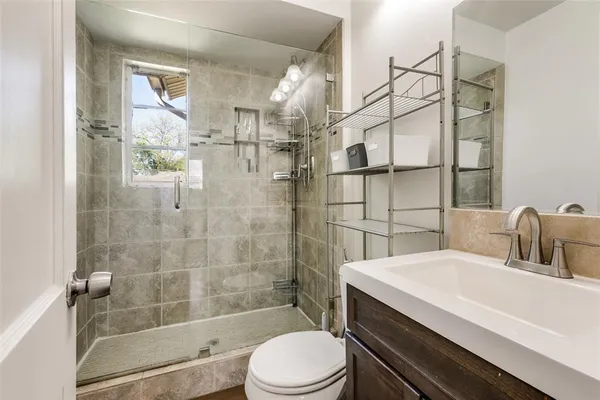 a bathroom with a sink a toilet and shower