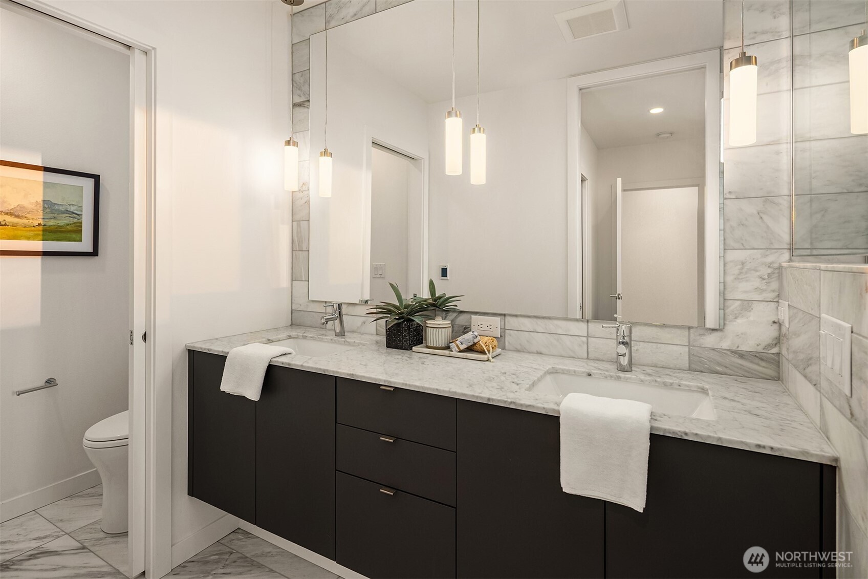 1910 8th Avenue West, Unit B Seattle, WA 98119 - Photo 23 of 40 a bathroom with a double vanity sink toilet and mirror