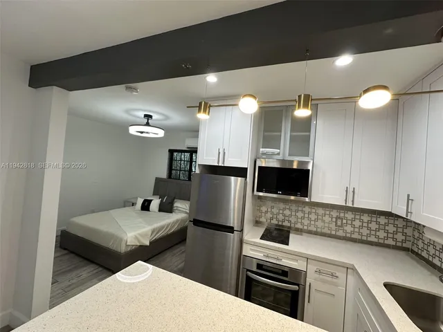 a kitchen with stainless steel appliances a refrigerator sink and stove