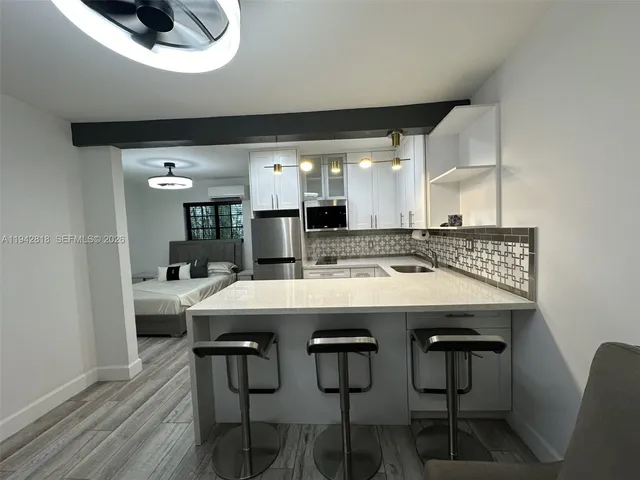 a kitchen with a dining table chairs and white cabinets