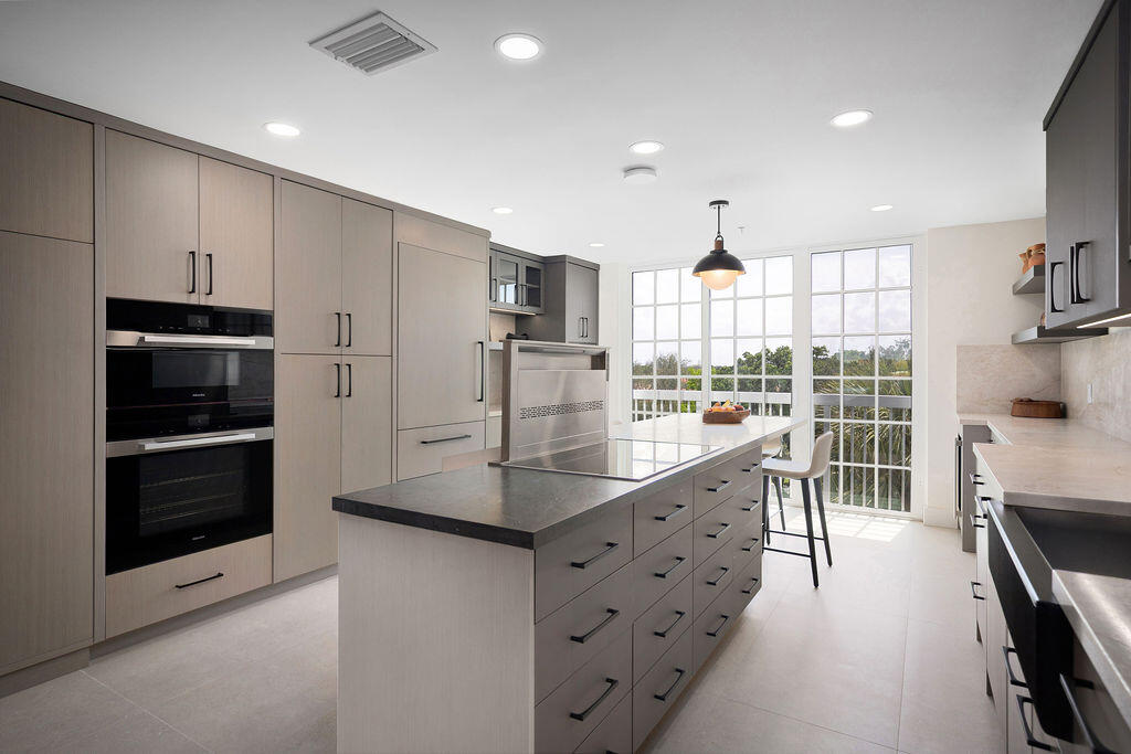 17031 Boca Club Boulevard, Unit 65A Boca Raton, FL 33487 - Photo 6 of 34 a kitchen with kitchen island granite countertop a stove a sink and a refrigerator