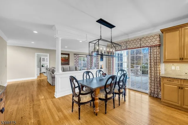 a dining room with furniture a chandelier and wooden floor