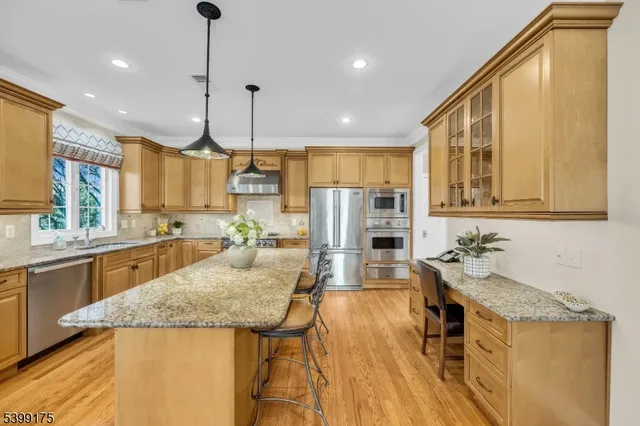 a kitchen with stainless steel appliances granite countertop a sink a stove and a wooden floors