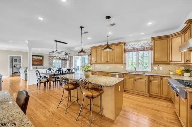 a kitchen with stainless steel appliances granite countertop a table and chairs in it