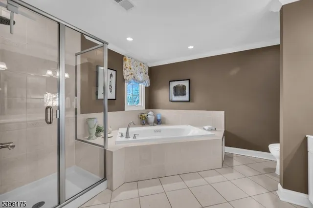 a spacious bedroom with a bed and a chandelier