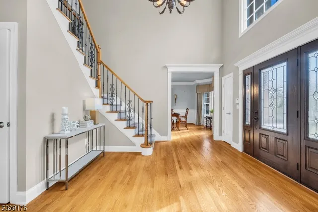 a view of a hallway with wooden floor and stairs